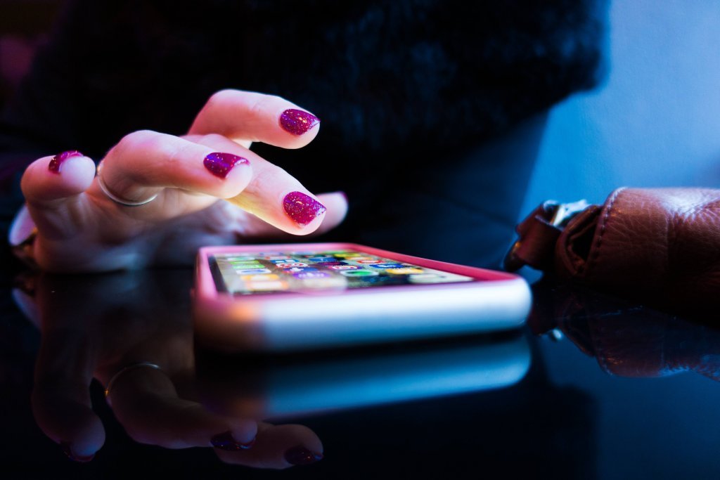 A finger is seen tapping a phone to play an event gamification app
